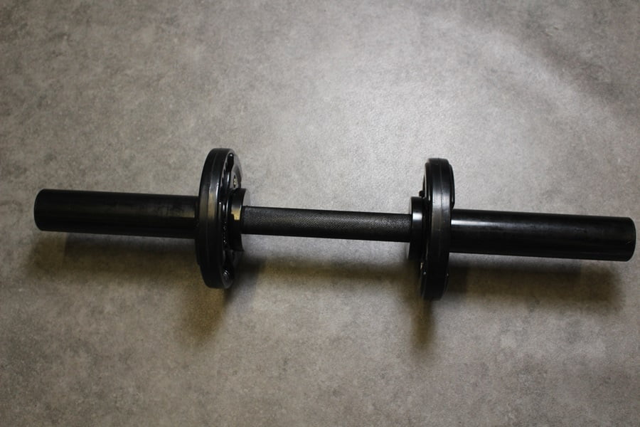 A dumbbell handle with loaded weight plates.