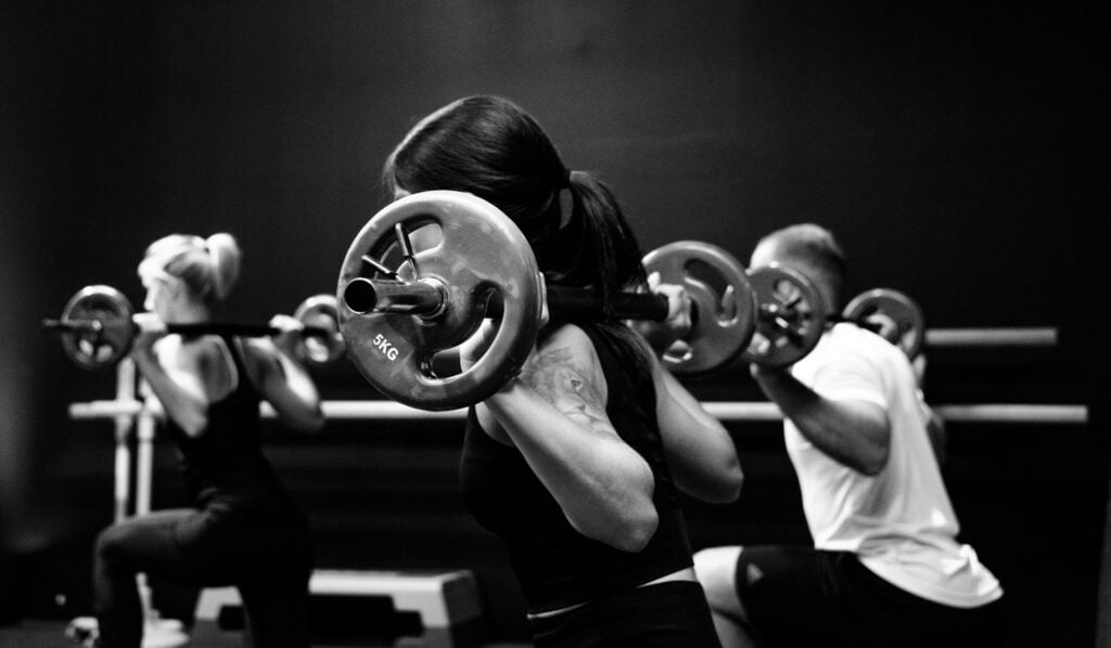 A group of people working out with barbells.